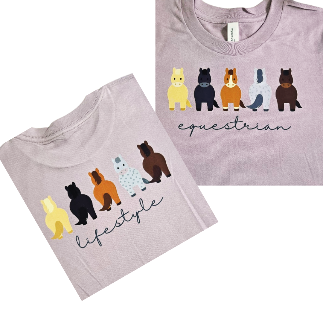 Two views of a light lavender crewneck t-shirt featuring a graphic of five stylized horses in different colors above the words 'equestrian' in script, with a second view showing 'lifestyle' in script.