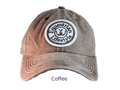A washed baseball cap in a medium brownish-gray color, labeled 'Coffee' underneath. It features a circular embroidered patch on the front that reads 'Equestrian Lifestyle'.