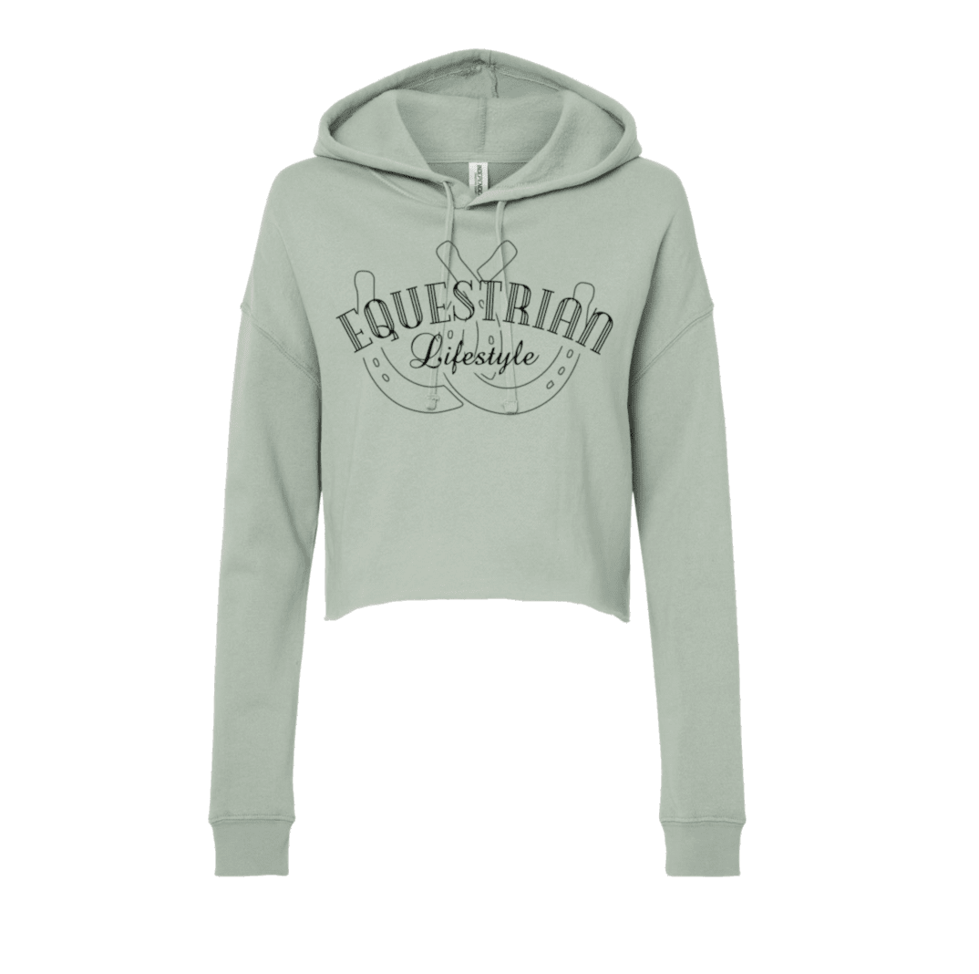 A light sage green cropped hoodie sweatshirt with a dark gray graphic on the chest reading 'EQUESTRIAN Lifestyle' over horseshoes, shown on a plain white background.