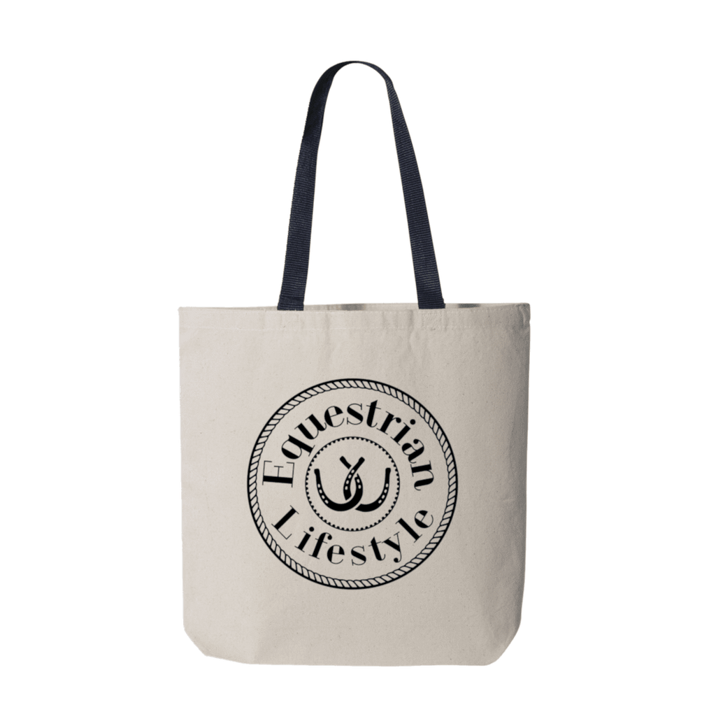 A canvas tote bag in a light beige color with dark navy blue shoulder straps, featuring a black circular graphic on the front that reads 'Equestrian Lifestyle' around an horseshoe illustration.