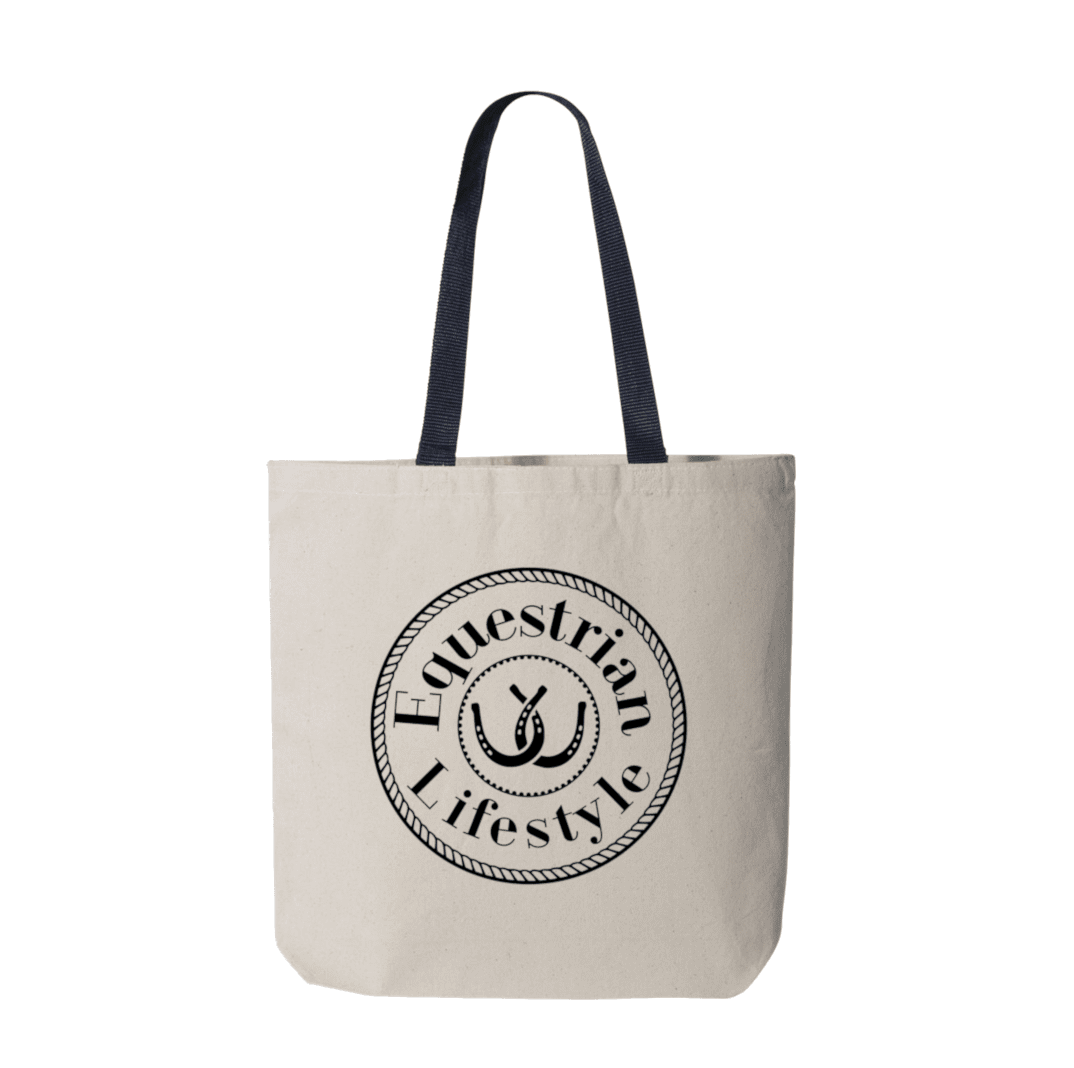 A canvas tote bag in a light beige color with dark navy blue shoulder straps, featuring a black circular graphic on the front that reads 'Equestrian Lifestyle' around an horseshoe illustration.
