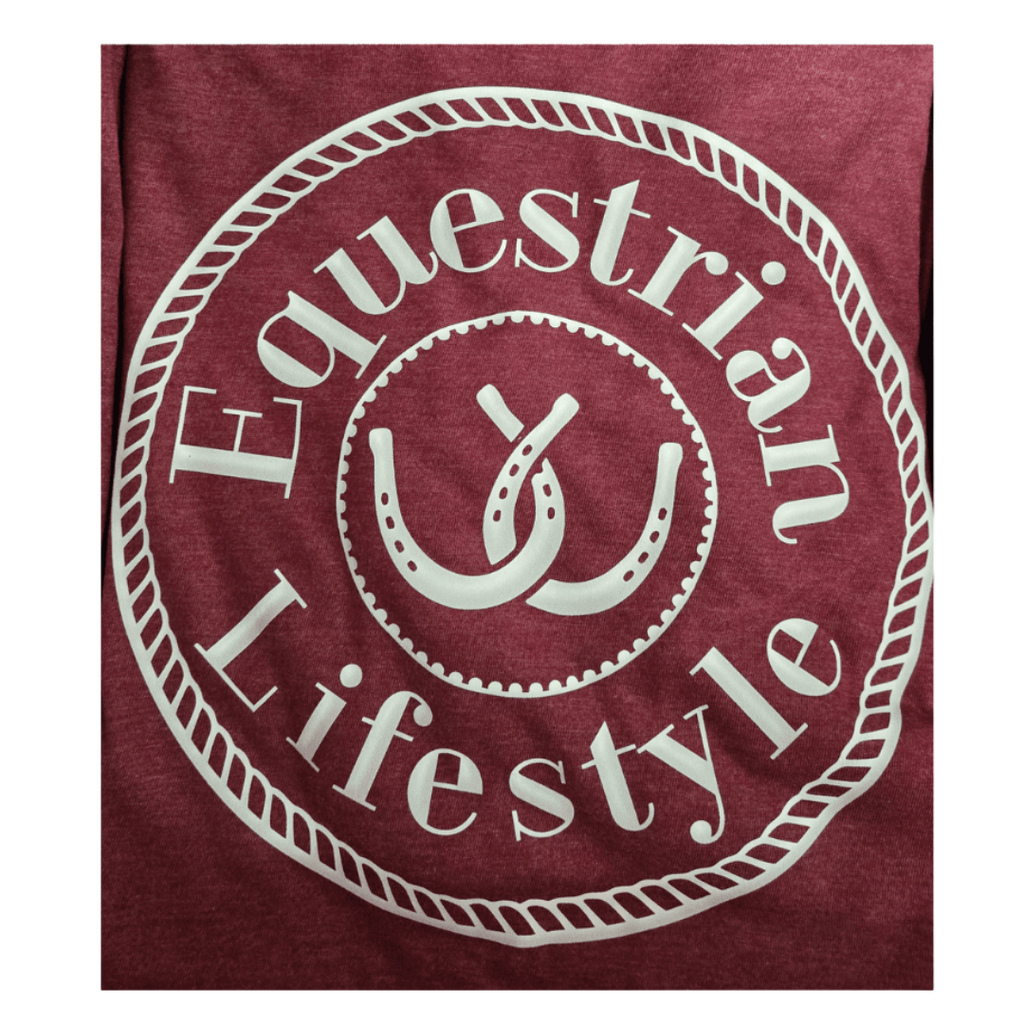 A close-up of a heathered maroon t-shirt featuring a large white circular graphic with the words 'Equestrian Lifestyle' and a central horseshoe design.