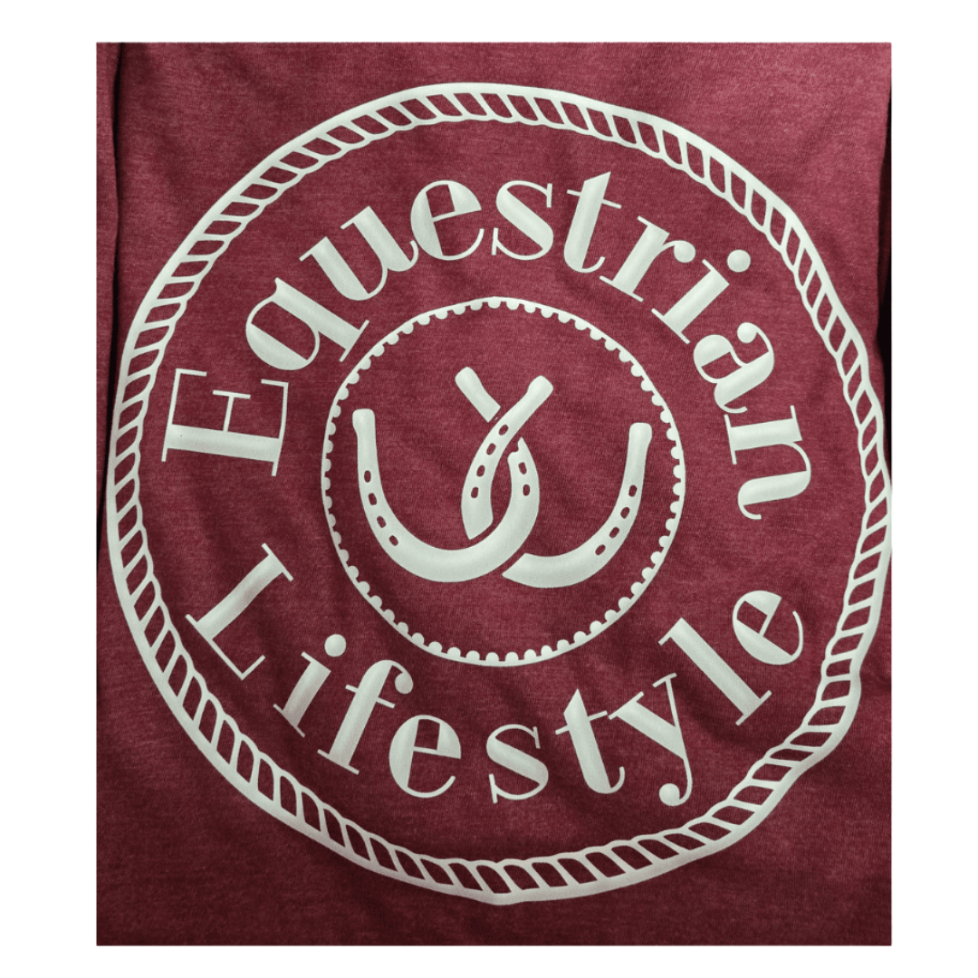 A close-up of a heathered maroon t-shirt featuring a large white circular graphic with the words 'Equestrian Lifestyle' and a central horseshoe design.