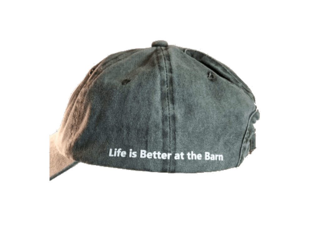 A washed black baseball cap with the white embroidered text 'Life is Better at the Barn' on the side, shown against a plain white background.