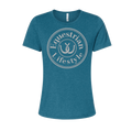 A women's short-sleeve crewneck t-shirt in heathered teal blue, featuring a circular white graphic on the chest with the words 'Equestrian Lifestyle' and a horseshoeillustration.