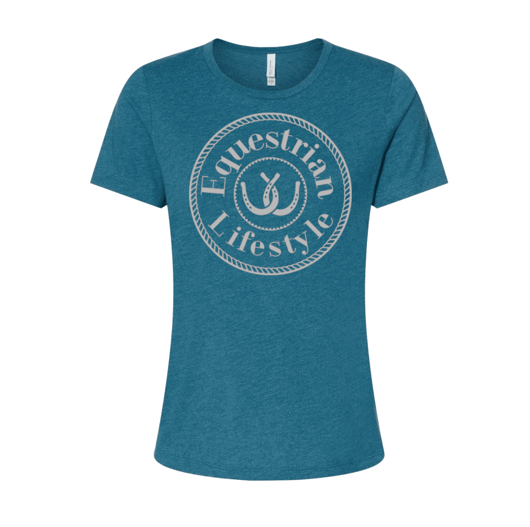 A women's short-sleeve crewneck t-shirt in heathered teal blue, featuring a circular white graphic on the chest with the words 'Equestrian Lifestyle' and a horseshoeillustration.