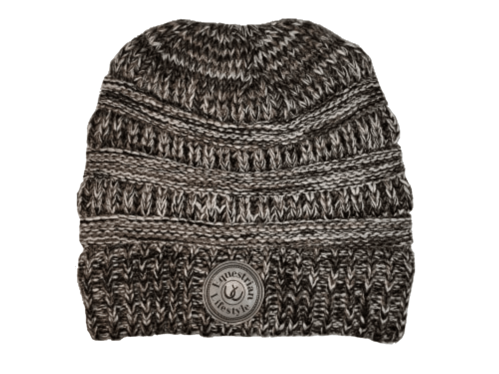A marled knit beanie hat in black and white, featuring horizontal textured stripes and a circular leatherette equestrian lifestyle brand patch on the front cuff.