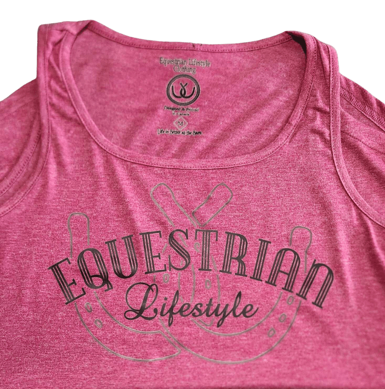 A close-up of a heather pink scoop-neck tank top featuring a dark gray graphic that reads 'EQUESTRIAN Lifestyle' with a horseshoe  design.
