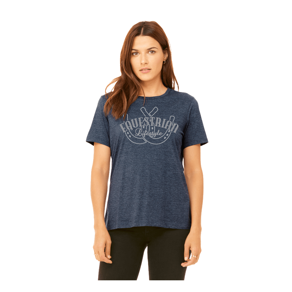 A woman modeling a heathered navy blue t-shirt with a white distressed graphic that reads 'EQUESTRIAN lifestyle'  and a horseshoe. She is wearing black leggings against a solid white background.