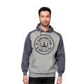 A man wearing a heather gray and navy blue raglan hoodie with a black circular graphic on the chest that reads 'Equestrian Lifestyle' with a horseshoe symbol, 