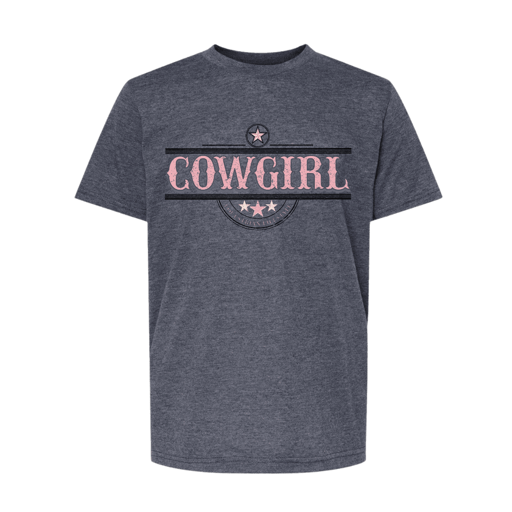 A dark heather gray t-shirt with a graphic on the chest featuring the word 'COWGIRL' in distressed pink letters, framed by black horizontal stripes and a circular emblem with stars.