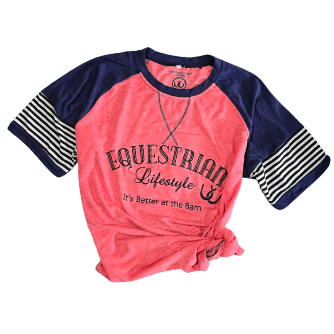 A women's raglan baseball-style t-shirt with a coral pink body and navy blue sleeves. The sleeves feature a navy and white striped pattern. Equestrian Lifestyle Its Better at the Barn